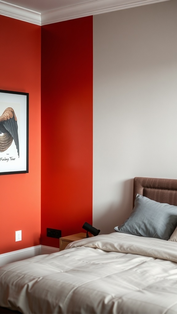 A bedroom featuring a bold red accent wall and a beige wall, with a bed and framed artwork.